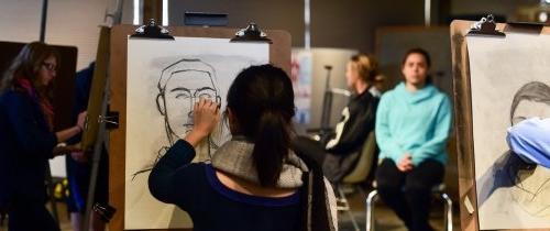 Students working at easels in a life drawing class
